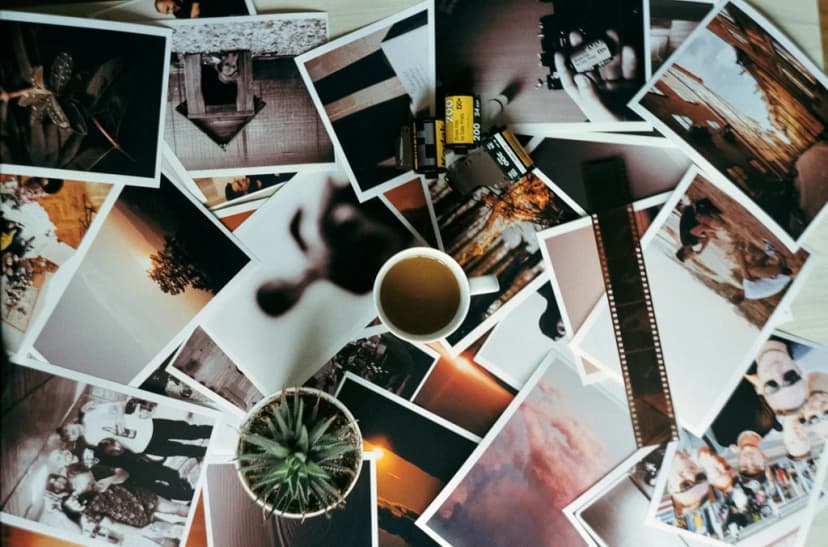 Person planning gallery wall layout with frames on floor